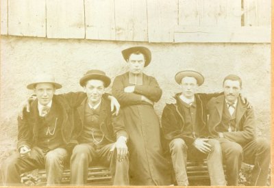 Photo d'un abbé entouré de 4 jeunes hommes